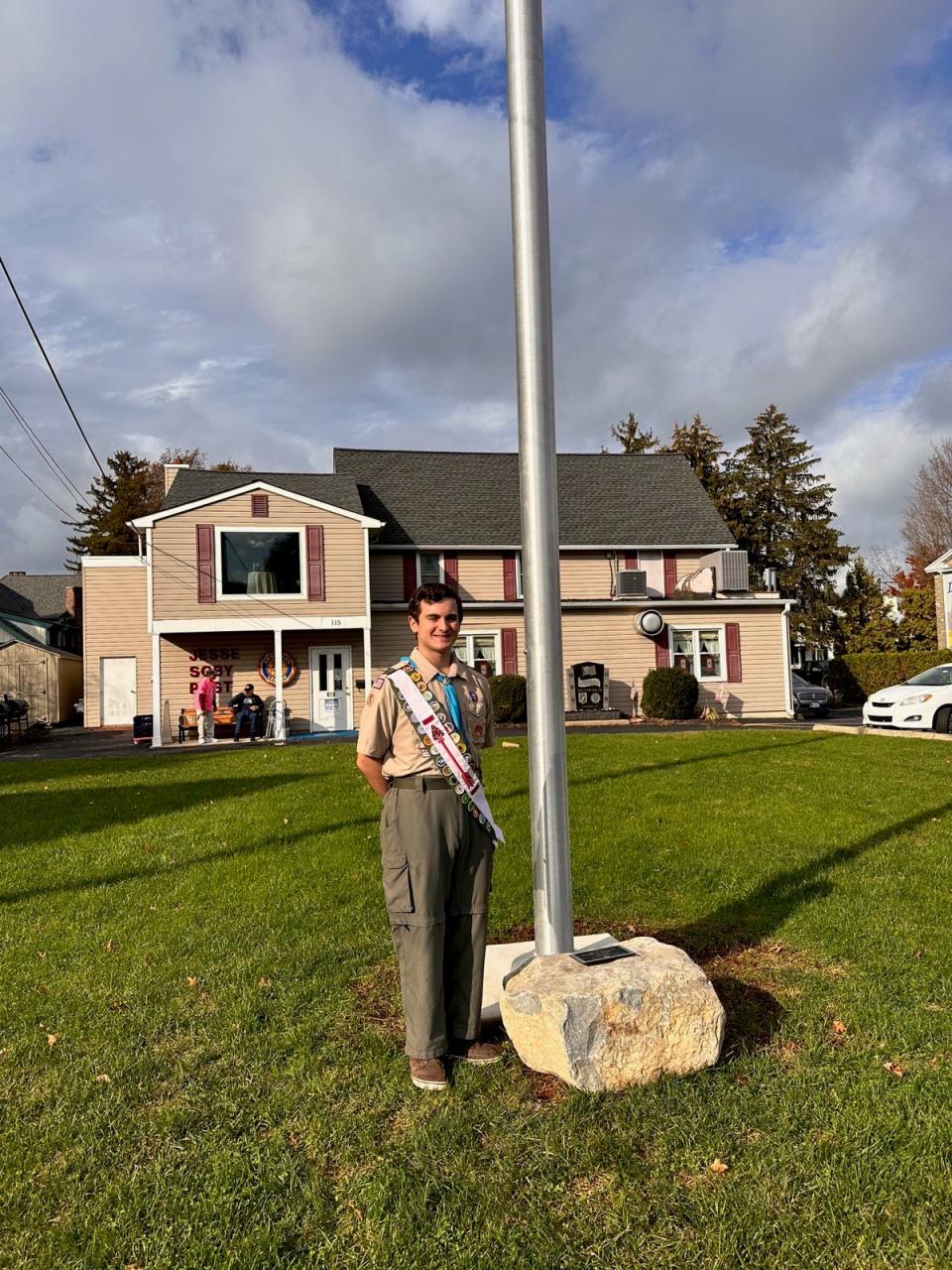 Timothy Bess of Levittown stands by the new flagpole in front of the Jesse W. Soby American Legion Post in Langhorne. He led the effort for the post to acquire and install the pole as an Eagle Scout project.