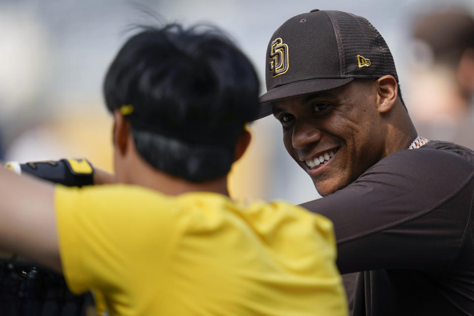 San Diego Padres right fielder Juan Soto, right, jokes with shortstop Ha-Seong Kim during batting practice for the Padres' baseball game against the Colorado Rockies on Wednesday, Aug. 3, 2022, in San Diego. (AP Photo/Gregory Bull)