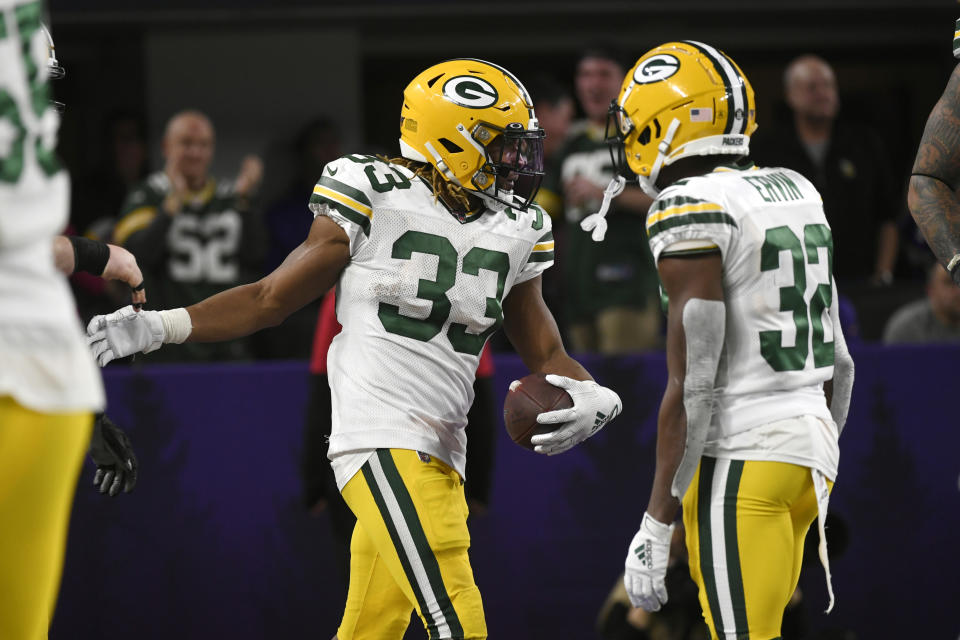 Green Bay Packers running back Aaron Jones (33) celebrates with Tyler Ervin after scoring on a 56-yard run during the second half of the team's NFL football game against the Minnesota Vikings, Monday, Dec. 23, 2019, in Minneapolis. (AP Photo/Craig Lassig)