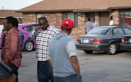 People stand outside an Islamic mosque located within an apartment complex, which federal authorities allege was to be targeted in a bomb plot by three Kansas men, is seen in Garden City, Kansas, U.S. October 14, 2016. REUTERS/Adam Shrimplin