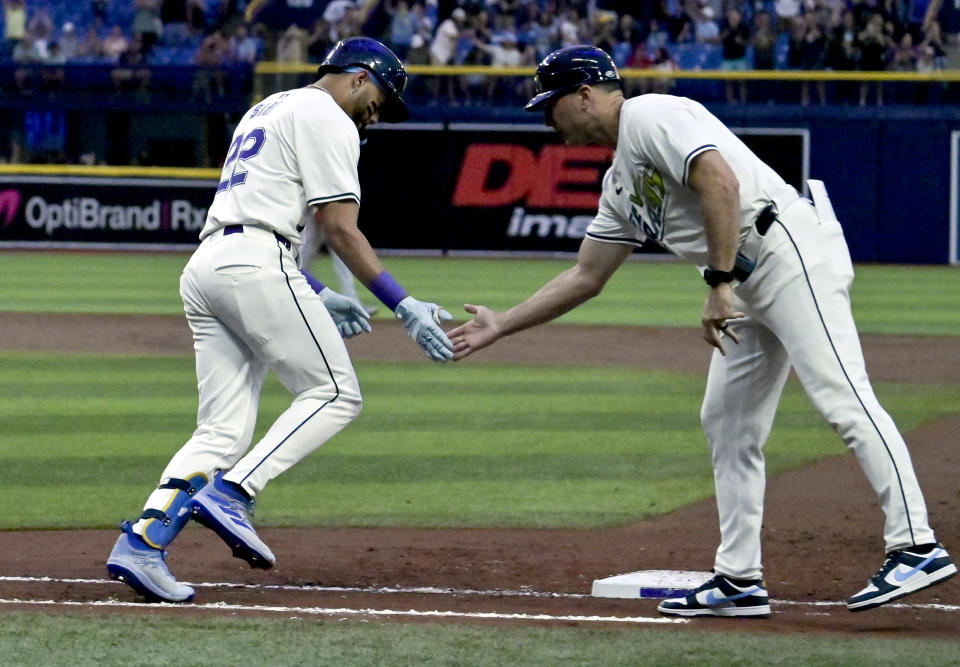 Tampa Bay Rays first base coach Michael Johns, right, congratulates Jose Siri, who runs the bases after hitting a solo home run off Washington Nationals starter Mitchell Parker during the second inning of a baseball game Friday, June 28, 2024, in St. Petersburg, Fla. (AP Photo/Steve Nesius)