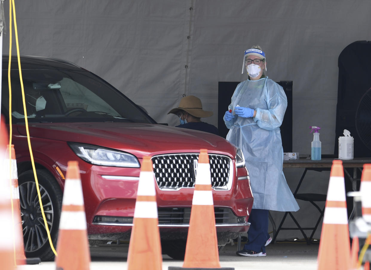 MIAMI GARDENS BEACH, FL - JULY 10: A Healthcare worker seen taking a swab sample from a driver at the Coronavirus (COVID-19) drive in testing site, set up in the parking lot of Hard Rock Stadium as Florida reports another record spike 11K in coronavirus cases, Floridaís Covid-19 surge shows the state's reopening plan is not working on July 10, 2020 in Miami Gardens, Florida. Credit: mpi04/MediaPunch /IPX