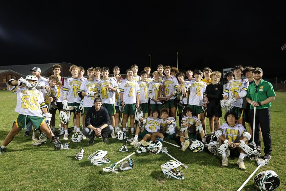 The Pensacola Catholic boys lacrosse team celebrates with its trophy after defeating West Florida in the District 1-1A championship game on Tuesday, April 16, 2024.