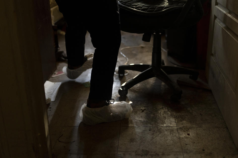 Arusyak Martirosyan, an investigator with the Los Angeles County Public Administrator's office, enters a micro-apartment to conduct a search in Los Angeles, Wednesday, Dec. 13, 2023, after a tenant was found dead in his bed. (AP Photo/Jae C. Hong)