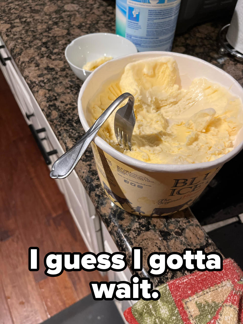 a bent fork in ice cream and the words "I guess I gotta wait"