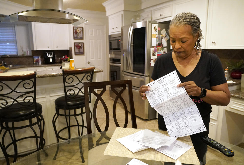 FILE -Pam Gaskin opens her mail-in primary election ballot, after multiple requests were rejected earlier this year, at her home Monday, Jan. 31, 2022, in Missouri City, Texas. The ruling Friday night, Feb. 11, 2022 by U.S. District Judge Xavier Rodriguez in San Antonio weakens new rules that make it a crime for election officials to proactively help voters get a ballot by mail. It orders Texas not to enforce that narrow part of the law against Harris County, which in 2020 sought to send more than 2 million Houston voters mail-in ballot applications during the pandemic.(Melissa Phillip/Houston Chronicle via AP, File)