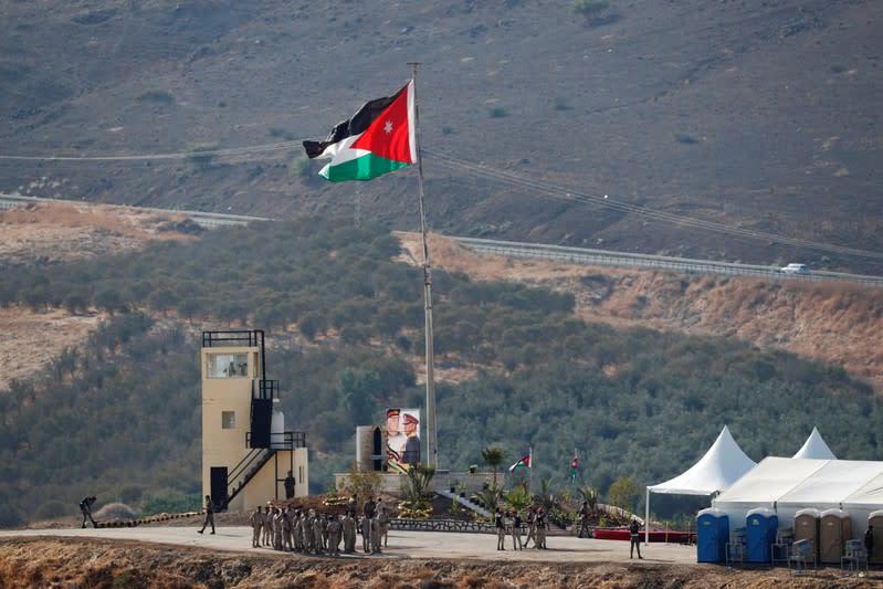 Jordanian soldiers gather near a tent and Jordan's national flag, in an area known as Naharayim in Hebrew and Baquora in Arabic, in the border area between Israel and Jordan, as seen from the Israeli side