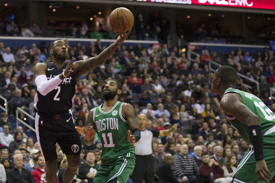 Washington Wizards guard John Wall (2) shoots in front of Boston Celtics guards Kyrie Irving (11) and Terry Rozier (12) during the first half of an NBA basketball game Wednesday, Dec. 12, 2018, in Washington. (AP Photo/Alex Brandon)