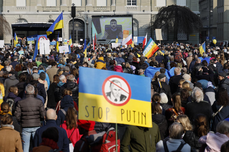 Ukrainian President Volodymyr Zelensky is displayed on a screen during a demonstration against the Russian invasion of Ukraine in front of the Swiss parliament building in Bern, Switzerland, Saturday, March 19, 2022. (Peter Klaunzer/Keystone via AP)