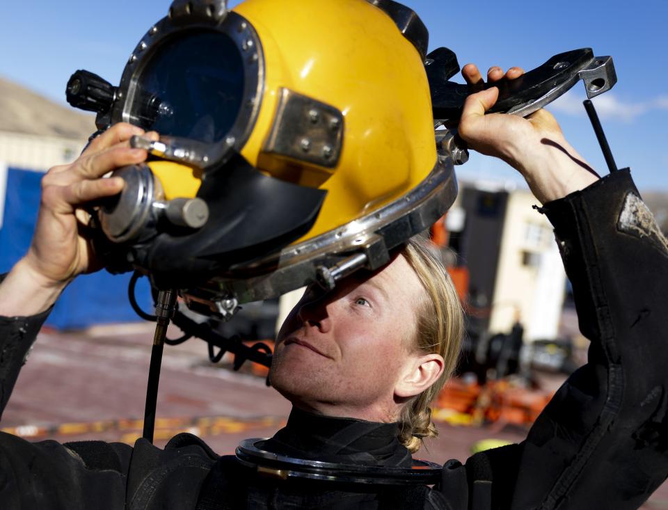 Underwater construction diver Christian Peterson puts on a 35-pound helmet before entering the water to grout the panels of the intake structure at the Deer Creek Intake Project in Heber City on Wednesday, Nov. 15, 2023. | Laura Seitz, Deseret News