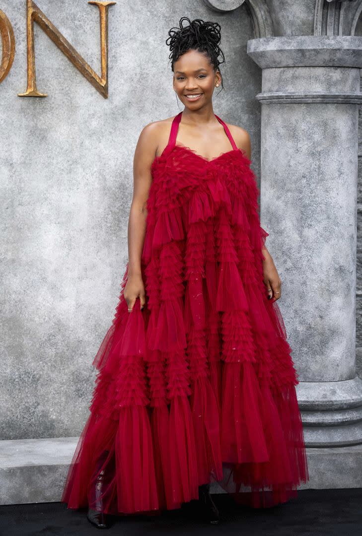 Bethany Antonia (Lady Baela Targaryen) lució un vestido colorado en capas de tul con escote corazón y finos breteles, que combinó con botas negras para la premiere de la serie en Londres