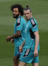 Real Madrid's Marcelo, left and Gareth Bale walk out onto the pitch before a Media Opening day training session in Madrid, Spain, Tuesday, May 24, 2022. Real Madrid will play Liverpool in Saturday's Champions League soccer final in Paris. (AP Photo/Manu Fernandez)