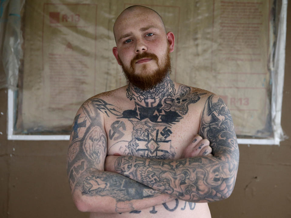 <p>Shane Johnson displays some of his tattoos as he poses in his home in Tippecanoe, Ind., Jan. 12, 2017. Johnson was born into extremism is in the process of covering some of his racist tattoos with new ones and wears long sleeves to hide remnants of his past he regrets. His father and many of his father’s relatives were part of the Klan, he said, so there was only one real way for him to go as a youth. (Photo: Michael Conroy/AP) </p>