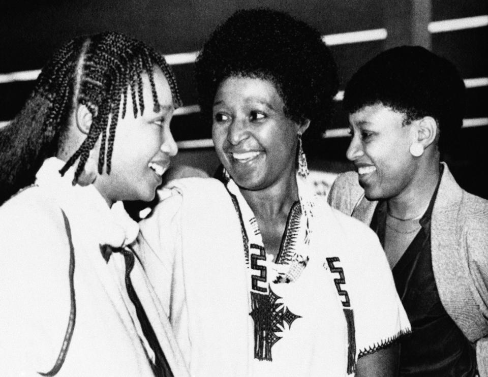 <p>Winnie Mandela, with daughters Dlamini, left, and Zinzi, right, arrives at Cape Town’s airport on Sept. 11, 1985, on her way to visit her imprisoned husband, anti-apartheid activist Nelson Mandela. (Photo: Greg English/AP) </p>