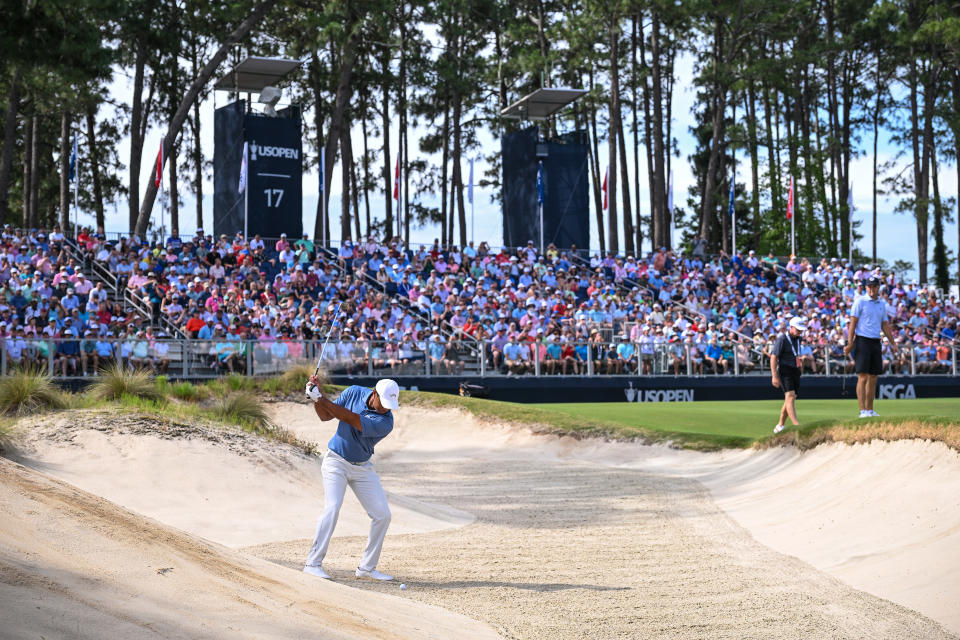 Tiger Woods plays a bunker shot on the 17th hole during Monday's practice round. (Ross Kinnaird/Getty Images)
