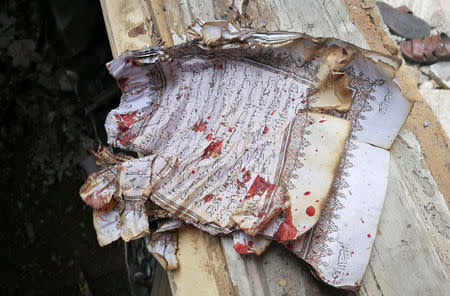 A partially burnt page of Koran is stained with blood following a twin bombing inside a mosque in Benghazi, Libya February 9, 2018. REUTERS/Stringer