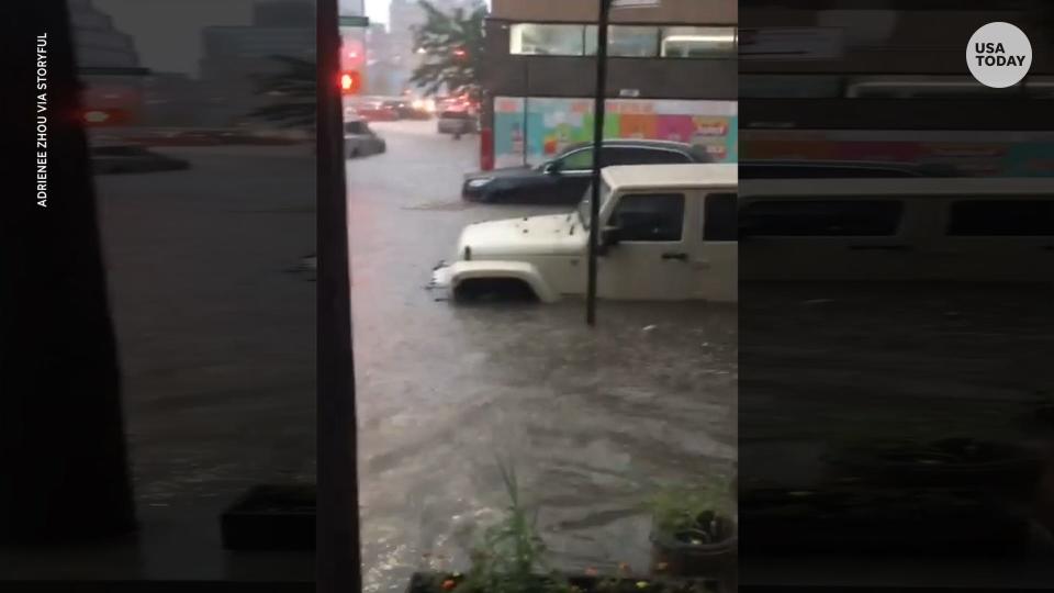 Knee-deep rain floods a Brooklyn street.