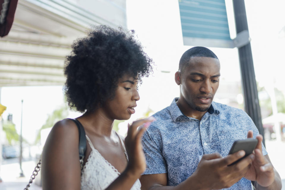 Two people looking at a smartphone together with engaged expressions