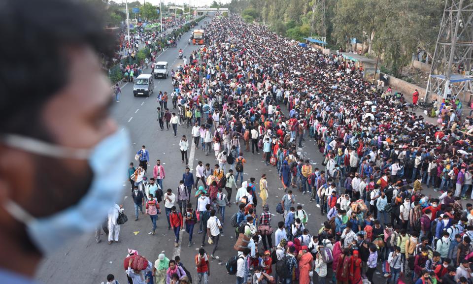 NEW DELHI, INDIA - MARCH 28: A wave of migrant workers seen at Anand Vihar Bus Terminus near the Delhi - UP border following Uttar Pradesh governments call to arrange buses for the workers returning to their native state, on Day 4 of the 21 day nationwide lockdown -- to check the spread of coronavirus, on March 28, 2020 in New Delhi, India. (Photo by Raj K Raj/Hindustan Times via Getty Images)