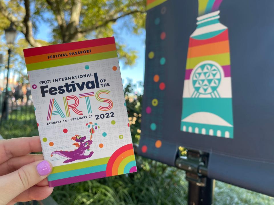 hand holding booklet for epcot's festival of the arts 2022