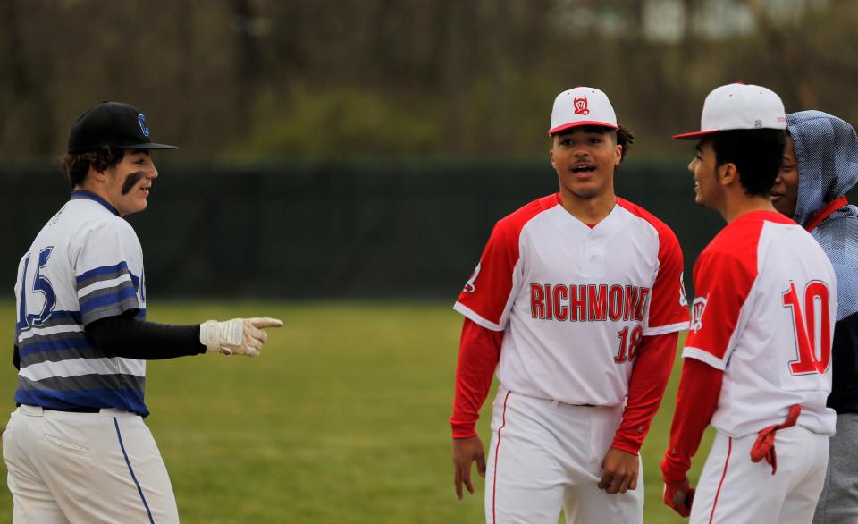 Richmond sophomores Dustin Moore (center) and D'Shaun Harper (right) talk with Centerville sophomore Gavin Robinson before their game April 7, 2022.