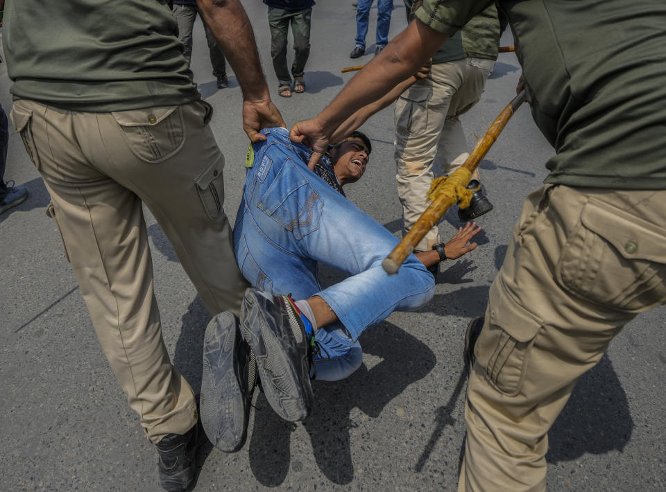 Indian policemen detain a Kashmiri Shiite Muslim for participating in a religious procession during restrictions in Srinagar, Indian controlled Kashmir, Sunday, Aug. 7, 2022. Authorities had imposed restrictions in parts of Srinagar, the region's main city, to prevent gatherings marking Muharram from developing into anti-India protests. (AP Photo/Mukhtar Khan)