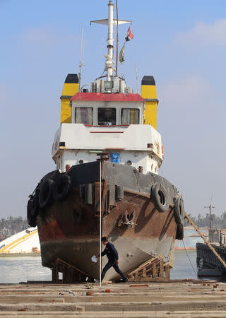 FILE PHOTO: A worker walks past an Iraqi ship at a shipyard built by the British Army on Basra's docks in 1916, in Basra, Iraq December 23, 2018. Picture taken December 23, 2018. REUTERS/Essam al-Sudani