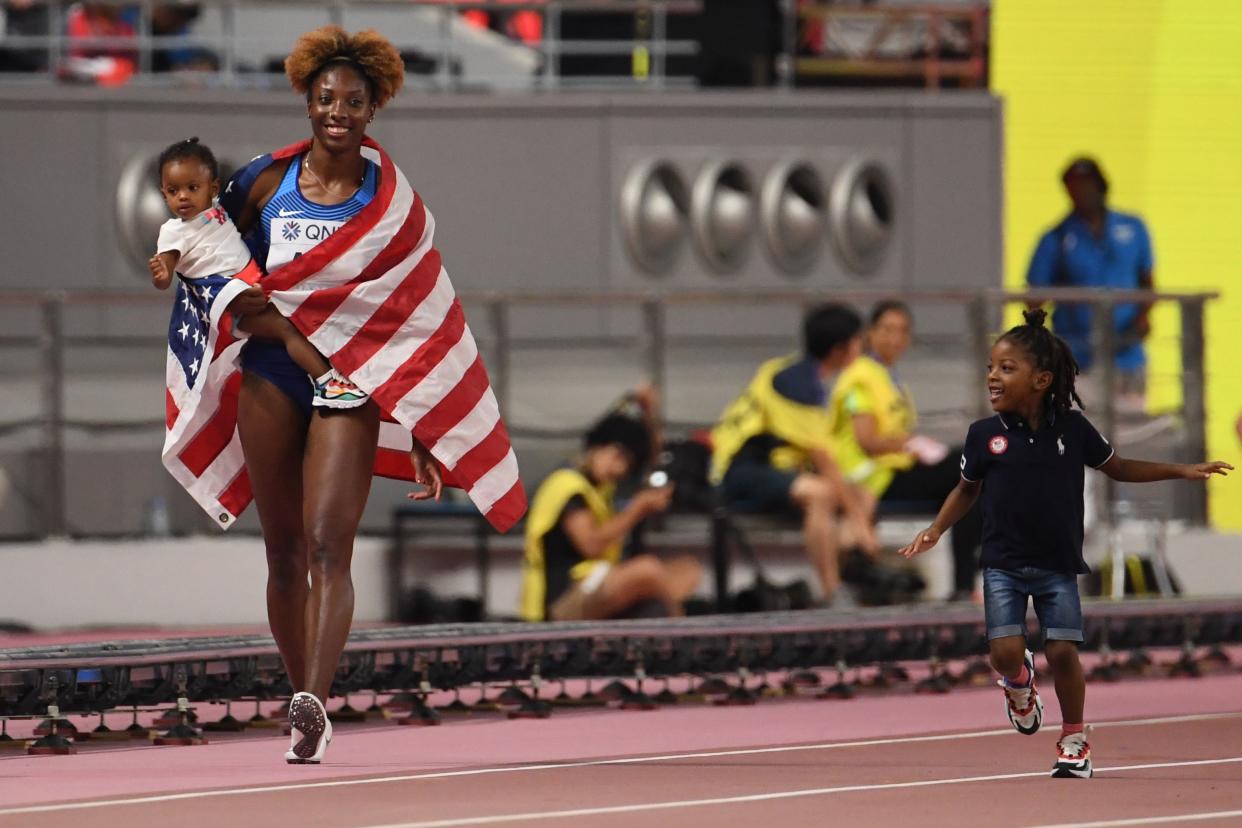 USA's Nia Ali walks with her children after winning the Women's 100m Hurdles final at the 2019 IAAF Athletics World Championships at the Khalifa International stadium in Doha on October 6, 2019. (Photo by Jewel SAMAD / AFP) (Photo by JEWEL SAMAD/AFP via Getty Images)