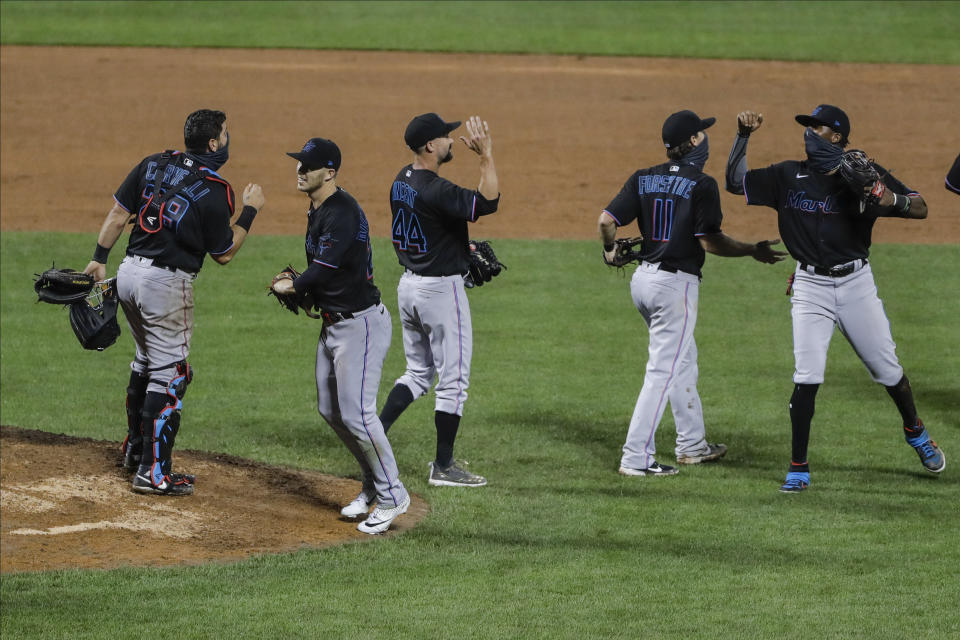 Miami Marlins' Francisco Cervelli (29) Nick Vincent (44) and Logan Forsythe (11) celebrate with teammates after a baseball game against the New York Mets Friday, Aug. 7, 2020, in New York. The Marlins won 4-3. (AP Photo/Frank Franklin II)