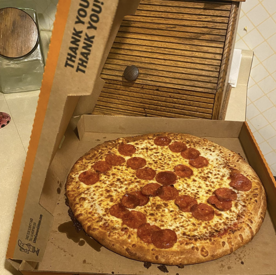 Photo shows the pizza with the pieces of pepperoni arranged to form the shape of a backward swastika.