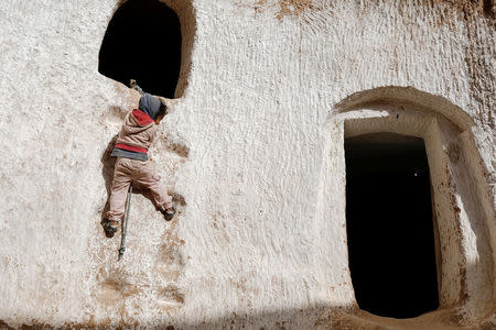 Ahlem, four, climbs up a wall to reach her rabbit's hideaway at her troglodyte house on the outskirts of Matmata, Tunisia, February 5, 2018. REUTERS/Zohra Bensemra