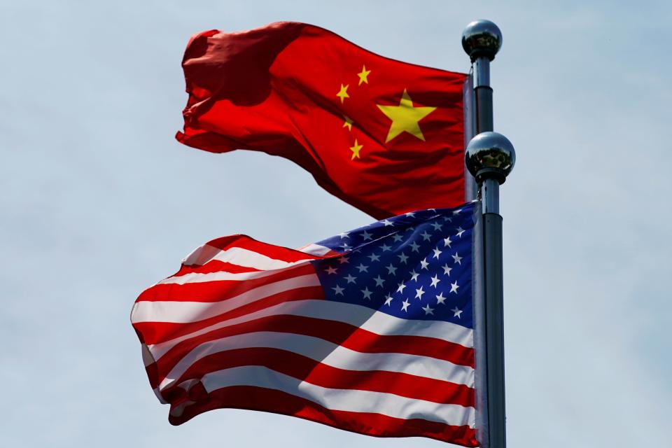 FILE PHOTO - Chinese and U.S. flags flutter near The Bund, before U.S. trade delegation meet their Chinese counterparts for talks in Shanghai, China July 30, 2019.  REUTERS/Aly Song