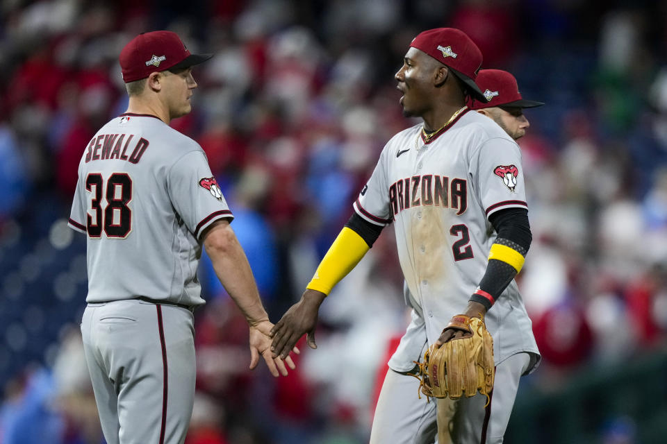 Arizona Diamondbacks relief pitcher Paul Sewald and shortstop Geraldo Perdomo celebrate their win against the Philadelphia Phillies afterGame 6 of the baseball NL Championship Series in Philadelphia Monday, Oct. 23, 2023. (AP Photo/Matt Slocum)