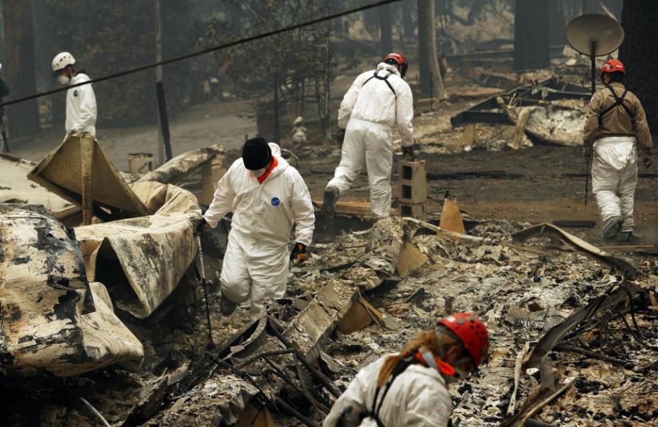 Rescue workers search for human remains at a trailer park burned out from the Camp fire in Paradise.