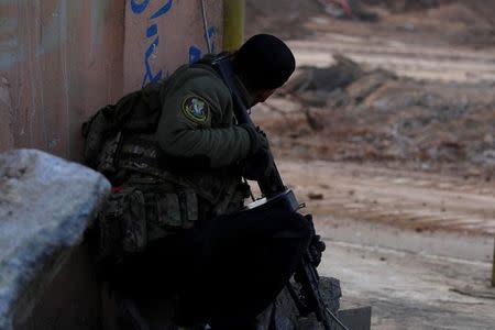 A member of Iraqi Special Operations Forces (ISOF) take cover during clashes with Islamic State militants in frontline near the University of Mosul, Iraq, January 13, 2017. REUTERS/Ahmed Saad/Files