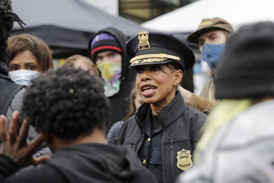 Seattle Police Chief Carmen Best talks with activists near a plywood-covered and closed Seattle police precinct Tuesday, June 9, 2020, in Seattle, following protests over the death of George Floyd, a black man who was in police custody in Minneapolis. Under pressure from city councilors, protesters and dozens of other elected leaders who have demanded that officers dial back their tactics, the police department on Monday removed barricades near its East Precinct building in the Capitol Hill neighborhood, where protesters and riot squads had faced off nightly. Protesters were allowed to march and demonstrate in front of the building, and the night remained peaceful. (AP Photo/Elaine Thompson)