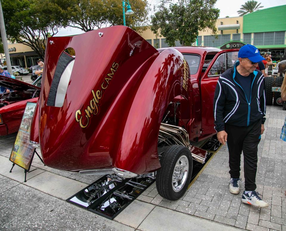 A man walks by a 1941 Studebaker Gasser at the Muscle on the Beach Car Show at Old School Square in Delray Beach on Saturday.