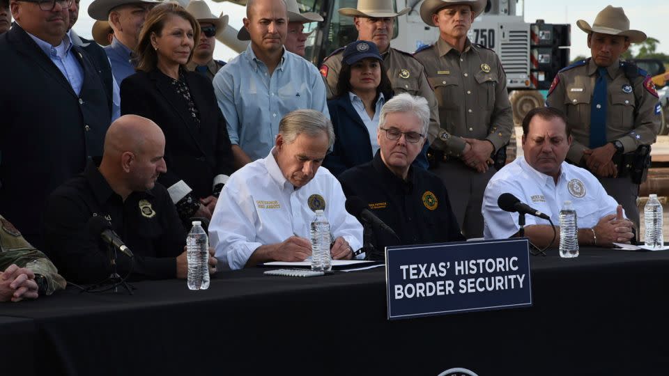Gov. Greg Abbott signs three bills into law at a border wall construction site in Brownsville, Texas on Monday, Dec. 18, 2023, that will broaden his border security plans and add funding for more infrastructure to deter illegal immigration. - Valerie Gonzalez/AP