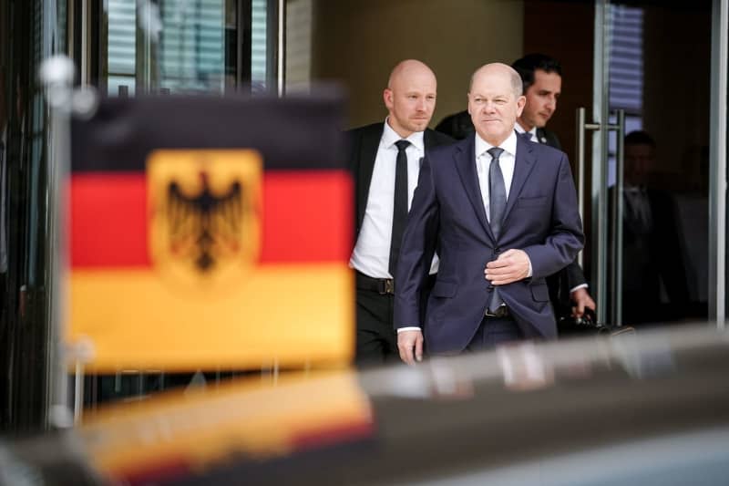 Germany's Chancellor Olaf Scholz (C) comes out of the hotel in Aqaba for the onward journey to Isreal. Kay Nietfeld/dpa