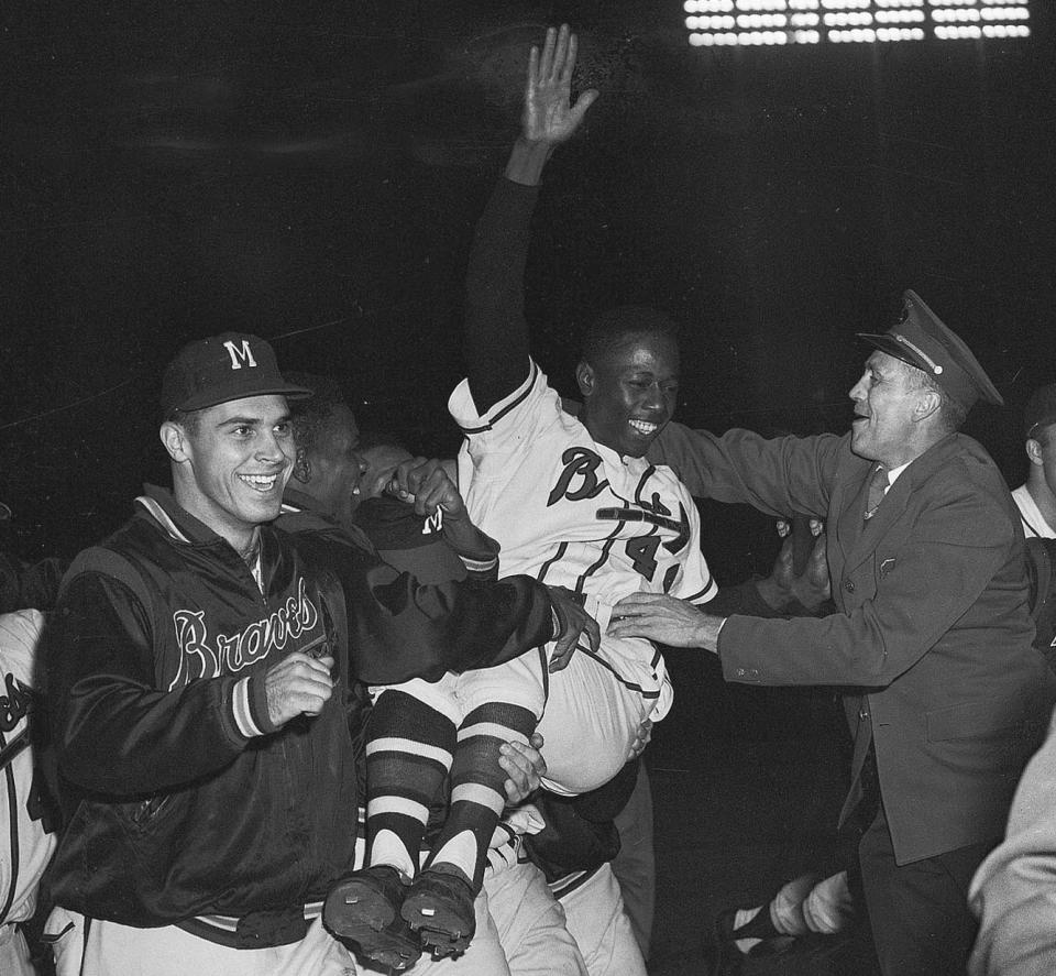 FILE - In this Sept. 23, 1957, file photo, Milwaukee Braves' Hank Aaron is carried from the baseball field by teammates after they won the National League pennant with a 4-2 victory against the St. Louis Cardinals, in Milwaukee. Hank Aaron, who endured racist threats with stoic dignity during his pursuit of Babe Ruth but went on to break the career home run record in the pre-steroids era, died early Friday, Jan. 22, 2021. He was 86. The Atlanta Braves said Aaron died peacefully in his sleep. No cause of death was given. (AP Photo/File)