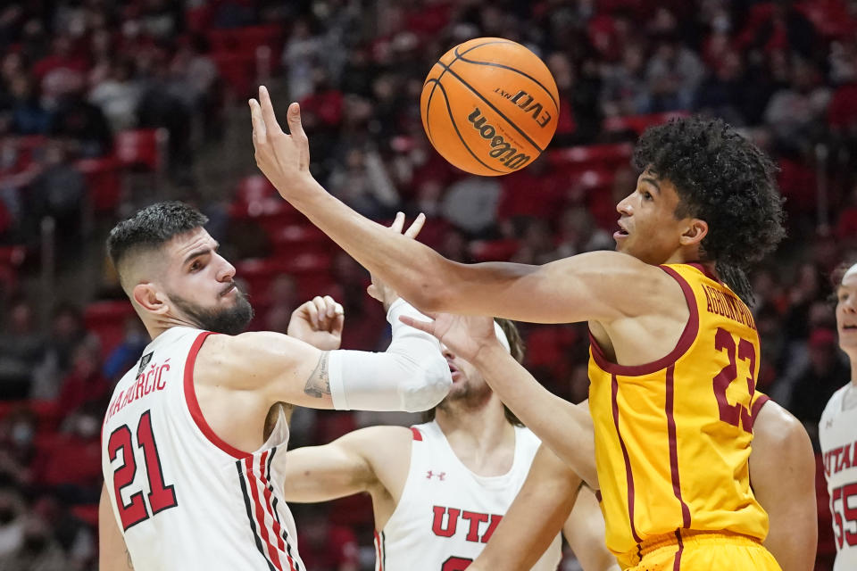 Utah forward Dusan Mahorcic (21) and Southern California forward Max Agbonkpolo (23) battle for a rebound in the first half during an NCAA college basketball game Saturday, Jan. 22, 2022, in Salt Lake City. (AP Photo/Rick Bowmer)