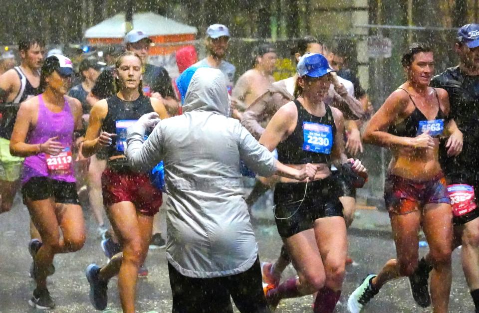 As heavy rain fell, along with thunder and lightning, members of the bike support team yelled, "The race is paused. Shelter in place." A few did step off the course, but most continued. Workers handing out water at first stopped working, but when they realized people weren’t stopping, they continued to handout water.