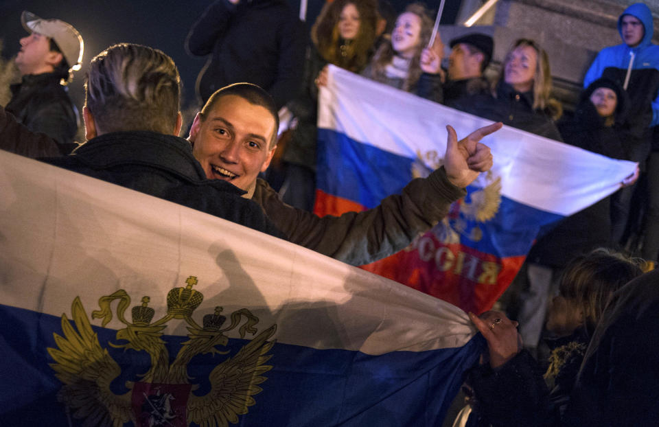 Pro-Russian people celebrate in the central square in Sevastopol, Ukraine, late Sunday, March 16, 2014. Russian flags fluttered above jubilant crowds Sunday after residents in Crimea voted overwhelmingly to secede from Ukraine and join Russia. The United States and Europe condemned the ballot as illegal and destabilizing and were expected to slap sanctions against Russia for it.(AP Photo/Andrew Lubimov)