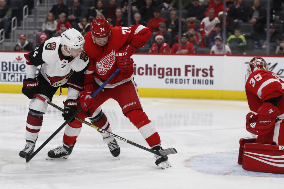 Arizona Coyotes center Carl Soderberg (34), checked by Detroit Red Wings defenseman Madison Bowey (74), watches his shot get past goaltender Jimmy Howard (35) for a goal during the second period of an NHL hockey game, Sunday, Dec. 22, 2019, in Detroit. (AP Photo/Carlos Osorio)