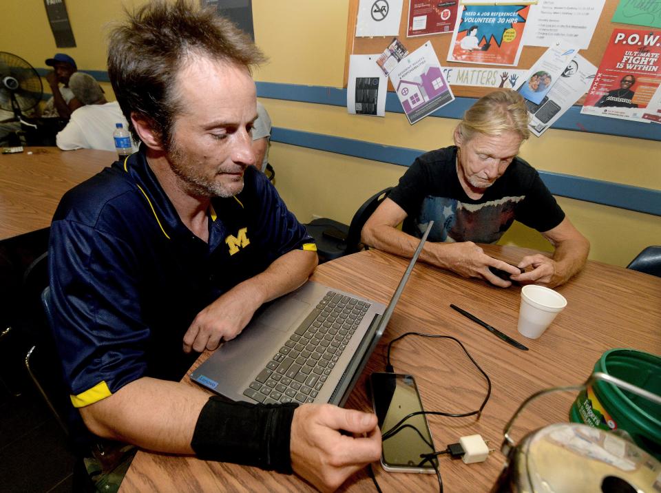 Jason Lemons of Springfield, front, and Micky Henson, also of Springfield, take a break from the heat Wednesday, August 23, 2023, at a cooling center located at the Washington Street Mission in Springfield.