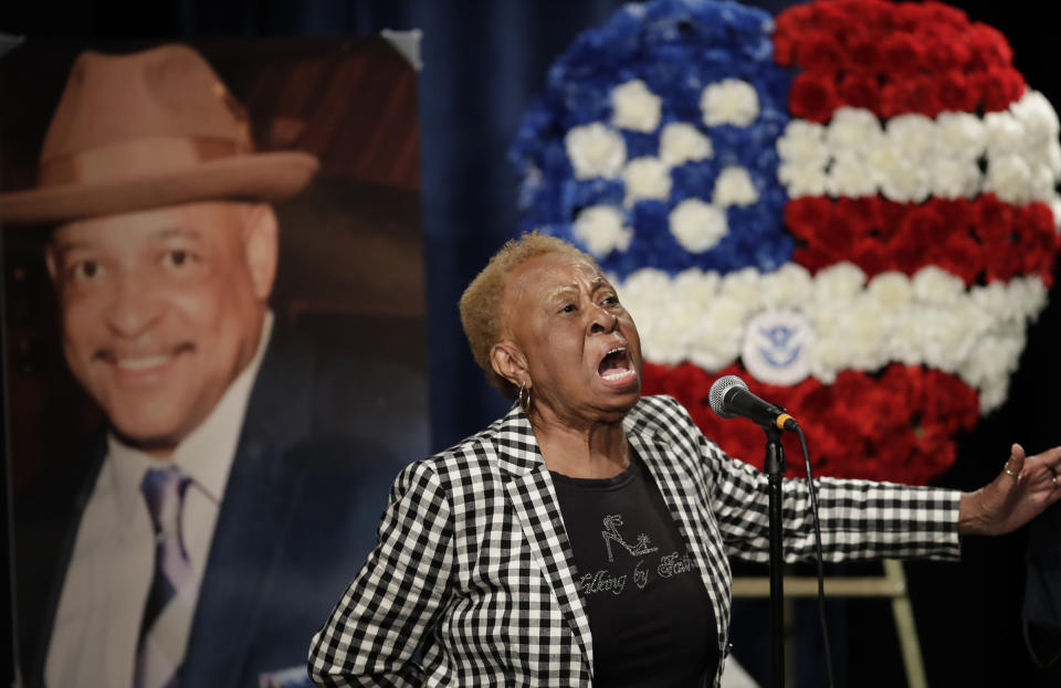 Janie Taylor sings beside a photo of Federal Protective Services Officer Dave Patrick Underwood on Friday, June 19, 2020, in Pinole, Calif. Underwood was fatally shot as he was guarding the Ronald V. Dellums Federal Building in Oakland, Calif., amid protests on May 29. (AP Photo/Ben Margot)