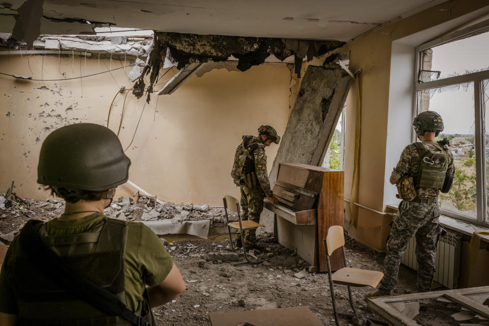 Soldados ucranianos caminan a través de las ruinas de una escuela en la región de Nicolaiev, al sur de Ucrania, a unos pocos kilómetros de las líneas rusas en la región de Jersón, el 11 de agosto de 2022. (Daniel Berehulak/The New York Times)