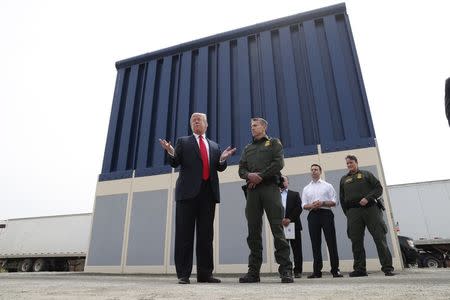 U.S. President Donald Trump talks with a U.S. Customs and Border Protection (CBP) Border Patrol Agent while participating in a tour of U.S.-Mexico border wall prototypes near the Otay Mesa Port of Entry in San Diego, California. U.S., March 13, 2018. REUTERS/Kevin Lamarque