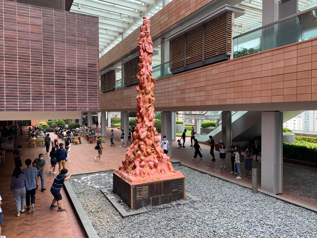 The Pillar of Shame sculpture displayed in the middle of a building's courtyard.
