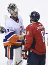 Washington Capitals left wing Alex Ovechkin (8) shakes hands with New York Islanders goaltender Semyon Varlamov (40) after the Capitals were eliminated after an NHL Stanley Cup playoff hockey game in Toronto on Thursday, Aug. 20, 2020. (Nathan Denette/The Canadian Press via AP)